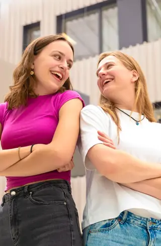 Meid roze shirt en meid wit shirt schouder aan schouder